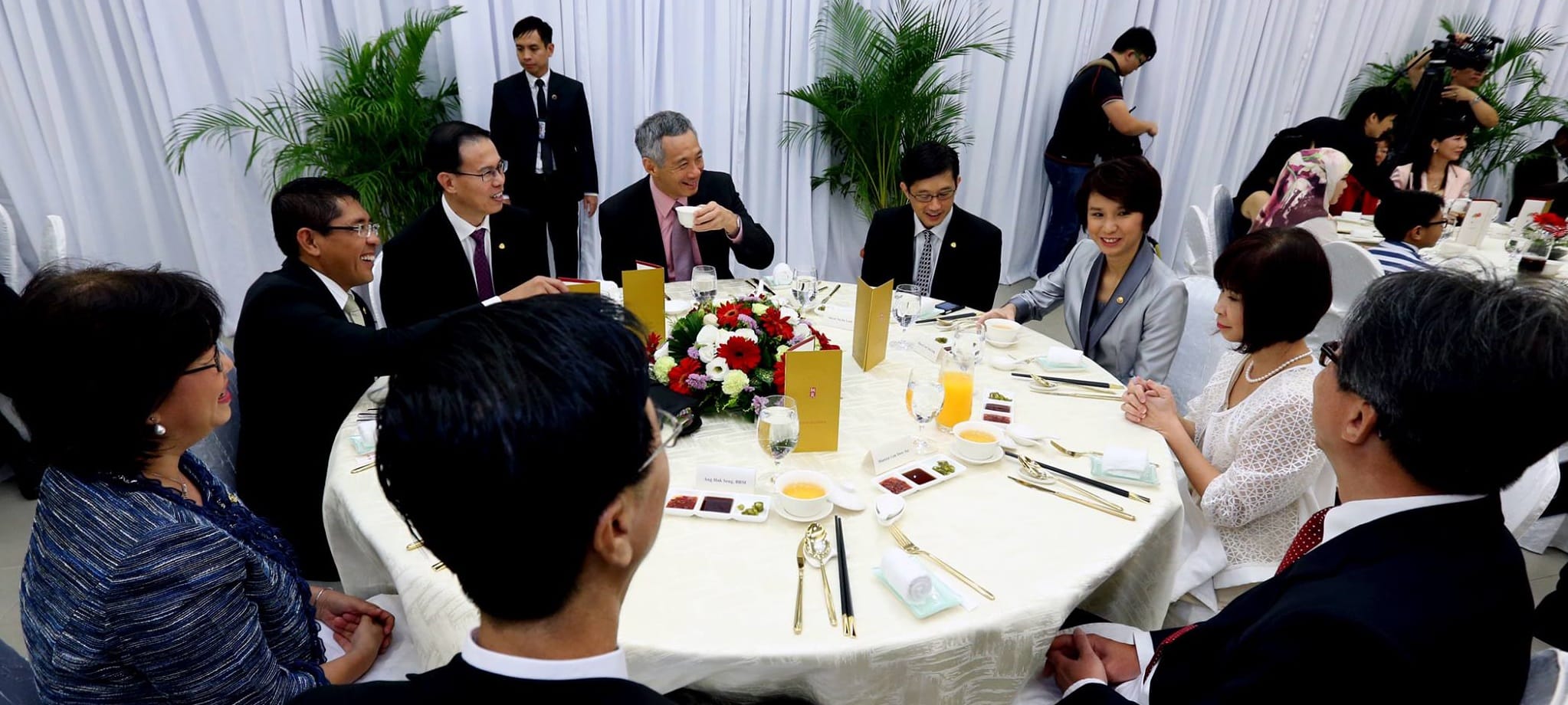 Lee Hsien Loong at a round table with people dressed in formal wear.